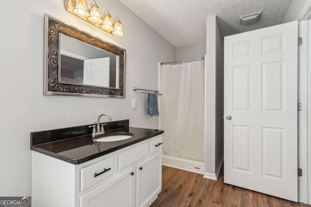 397 Harvey Lokey Rd, Bethlehem, GA 30620 - bathroom featuring vanity, wood finished floors, a shower with shower curtain, and a textured ceiling