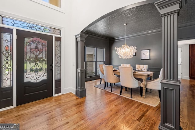 414 Dogwood Way, Canton, GA 30114 - foyer entrance with decorative columns, arched walkways, wood finished floors, a chandelier, and ornamental molding