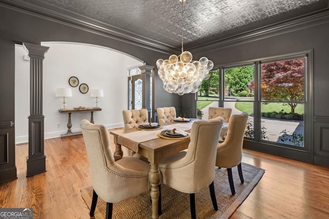 414 Dogwood Way, Canton, GA 30114 - dining room featuring decorative columns, ornamental molding, a chandelier, arched walkways, and light wood-type flooring