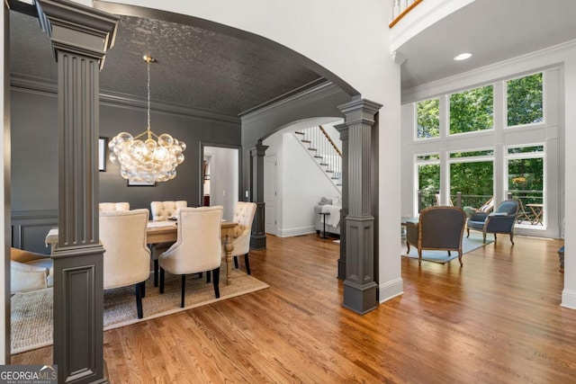 414 Dogwood Way, Canton, GA 30114 - dining area featuring decorative columns, ornamental molding, arched walkways, light wood-style floors, and stairway