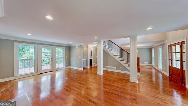 1477 Triple Creek Ct NW, Kennesaw, GA 30144 - unfurnished living room featuring decorative columns, crown molding, stairs, baseboards, and light wood-style floors
