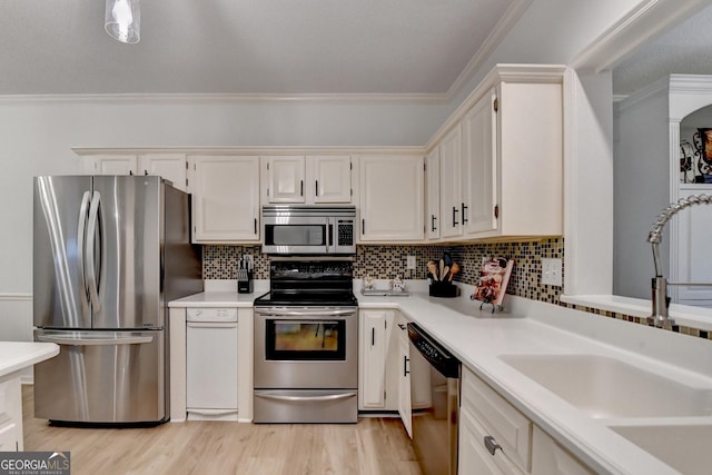 248 Riverview Trl, Roswell, GA 30075 - kitchen with stainless steel appliances, a sink, light countertops, light wood-type flooring, and crown molding