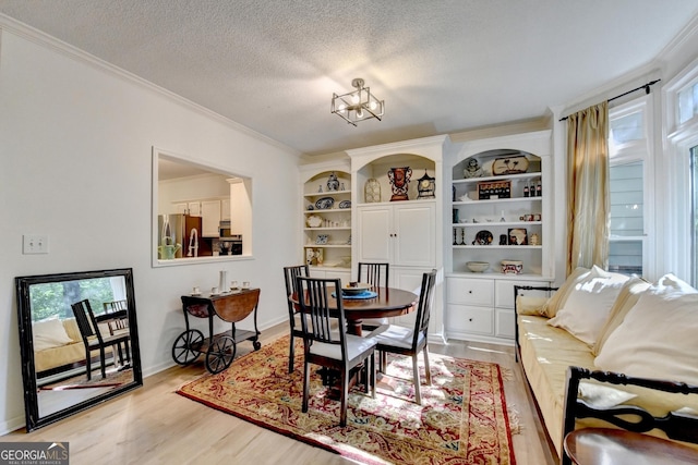 248 Riverview Trl, Roswell, GA 30075 - dining space featuring light wood-style flooring, crown molding, a textured ceiling, baseboards, and built in shelves