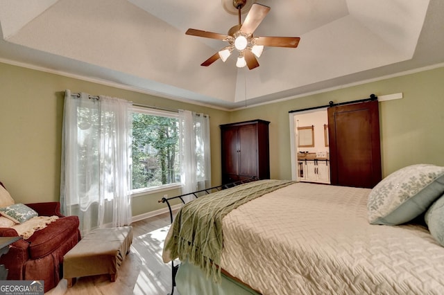 248 Riverview Trl, Roswell, GA 30075 - bedroom with a tray ceiling, light wood-style flooring, a barn door, ornamental molding, and a ceiling fan