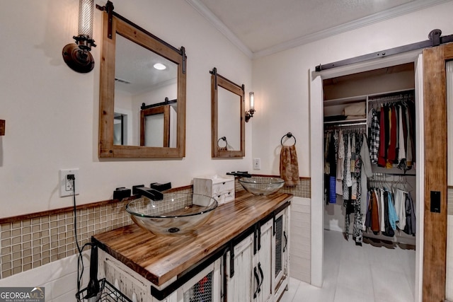 248 Riverview Trl, Roswell, GA 30075 - bathroom featuring double vanity, ornamental molding, tile walls, tile patterned flooring, and a spacious closet