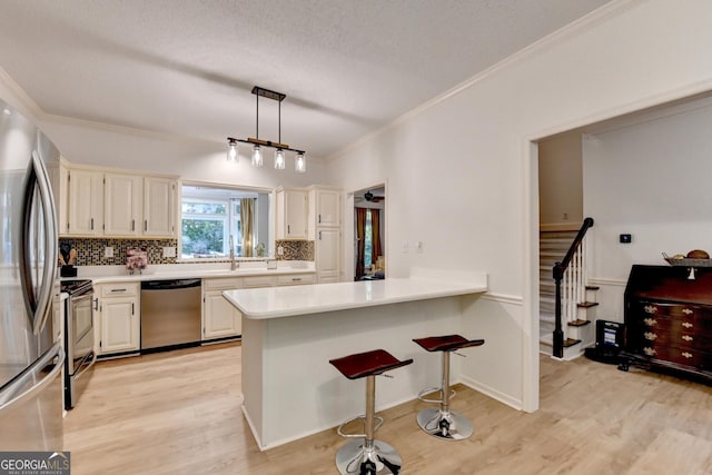 248 Riverview Trl, Roswell, GA 30075 - kitchen with appliances with stainless steel finishes, backsplash, light wood-style floors, a breakfast bar, and a peninsula