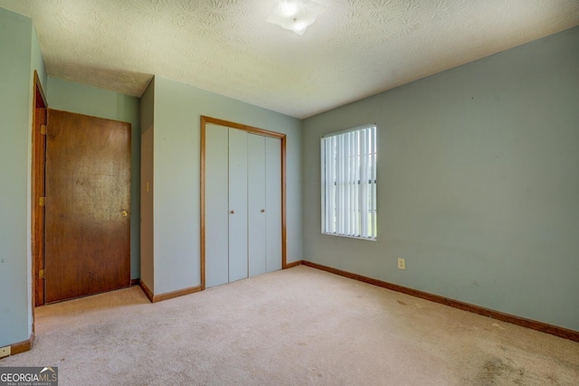 2809 S Ola Rd, Locust Grove, GA 30248 - unfurnished bedroom featuring a closet, carpet floors, baseboards, and a textured ceiling