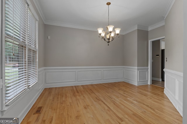 3642 Fowler Rdg, Douglasville, GA 30135 - empty room with a chandelier, light wood finished floors, crown molding, and a wainscoted wall