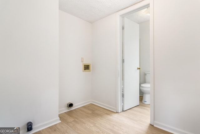 320 Edna Dr, Stockbridge, GA 30281 - laundry room featuring light wood finished floors, hookup for a washing machine, baseboards, and a textured ceiling