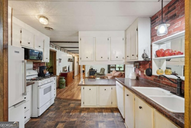 293 Timber Ridge Dr, Athens, GA 30607 - kitchen featuring white appliances, a sink, dark countertops, a peninsula, and decorative light fixtures