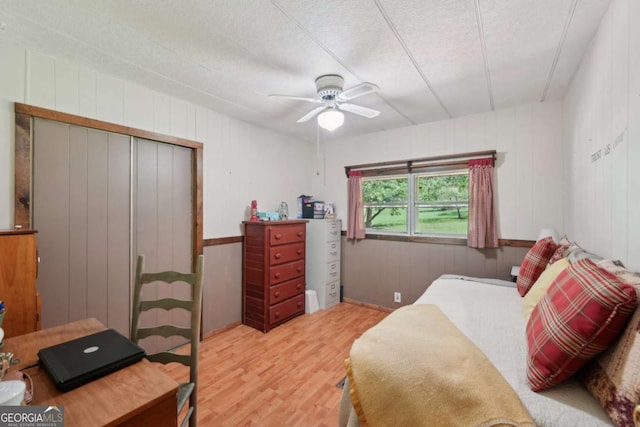 293 Timber Ridge Dr, Athens, GA 30607 - bedroom with wood finished floors, a closet, a ceiling fan, wood walls, and a textured ceiling