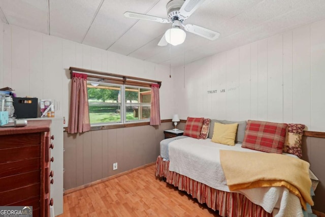293 Timber Ridge Dr, Athens, GA 30607 - bedroom with light wood finished floors, ceiling fan, wooden walls, and baseboards