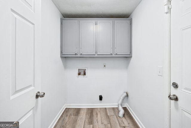 3210 Roseheath Ln, Lithonia, GA 30038 - washroom with hookup for an electric dryer, cabinet space, hookup for a washing machine, wood finished floors, and baseboards