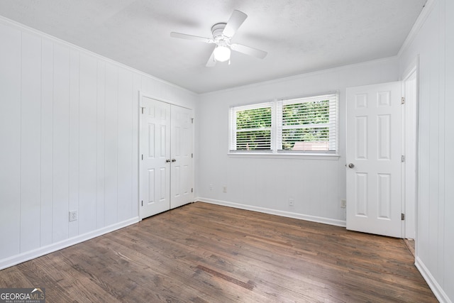 3210 Roseheath Ln, Lithonia, GA 30038 - unfurnished bedroom featuring dark wood-type flooring, ornamental molding, baseboards, and a ceiling fan