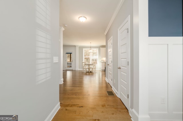 15 Jamilee Cv, Cartersville, GA 30120 - corridor with light wood finished floors, ornamental molding, and a chandelier