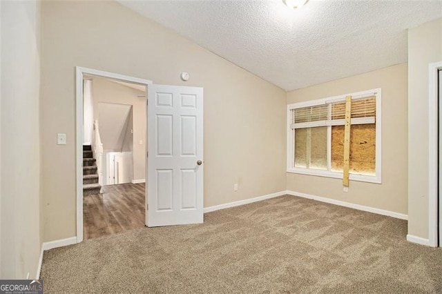 2641 Clifton Springs Rd, Decatur, GA 30034 - carpeted empty room with vaulted ceiling, a textured ceiling, baseboards, and stairs