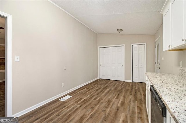 2641 Clifton Springs Rd, Decatur, GA 30034 - kitchen featuring stainless steel dishwasher, wood finished floors, lofted ceiling, white cabinetry, and baseboards