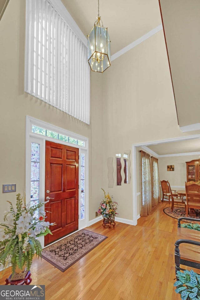 222 Mossy Pl, Alpharetta, GA 30005 - foyer featuring a high ceiling, a chandelier, wood finished floors, baseboards, and crown molding