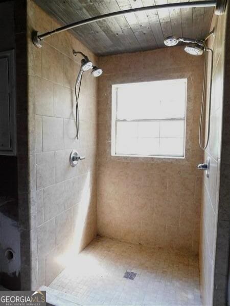 1306 Stonemont Rd, Auburn, GA 30011 - bathroom featuring a tile shower and wooden ceiling