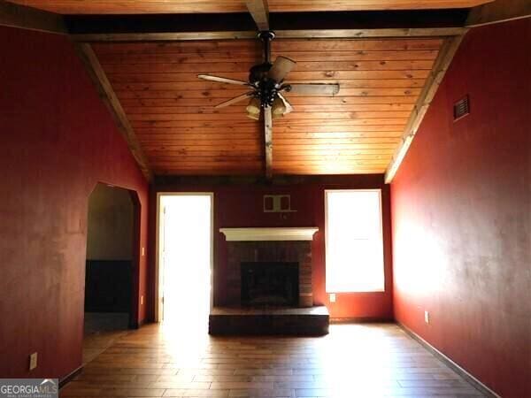 1306 Stonemont Rd, Auburn, GA 30011 - unfurnished living room featuring a ceiling fan, wood ceiling, hardwood / wood-style floors, a fireplace, and arched walkways