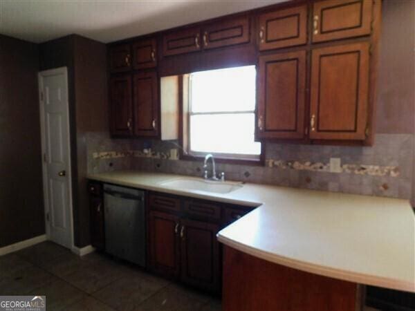 1306 Stonemont Rd, Auburn, GA 30011 - kitchen featuring stainless steel dishwasher, a sink, dark tile patterned floors, backsplash, and light countertops