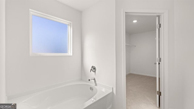 712 Curb Ct, Locust Grove, GA 30248 - bathroom featuring a garden tub and a spacious closet