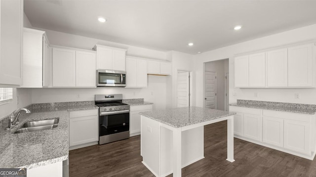712 Curb Ct, Locust Grove, GA 30248 - kitchen featuring appliances with stainless steel finishes, a sink, dark wood finished floors, light stone counters, and white cabinetry