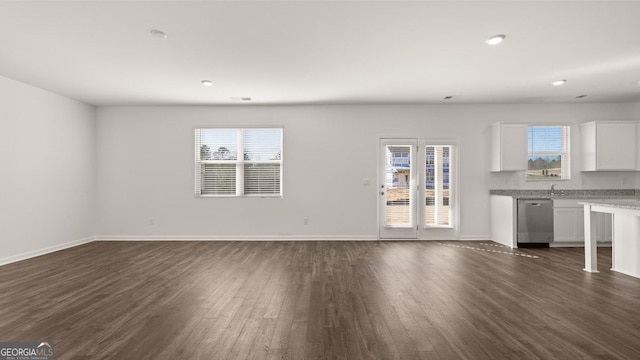 712 Curb Ct, Locust Grove, GA 30248 - unfurnished living room with dark wood finished floors, plenty of natural light, baseboards, and recessed lighting