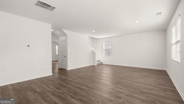 712 Curb Ct, Locust Grove, GA 30248 - unfurnished living room featuring stairway, dark wood finished floors, plenty of natural light, recessed lighting, and baseboards