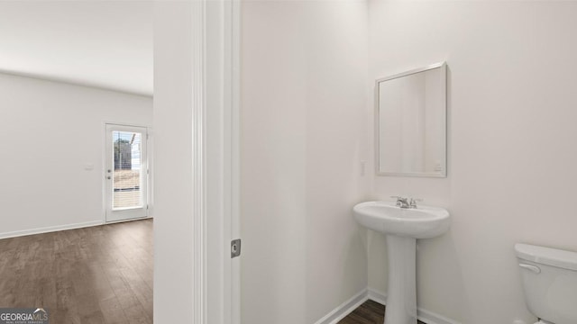 712 Curb Ct, Locust Grove, GA 30248 - half bath with toilet, wood finished floors, baseboards, and a sink