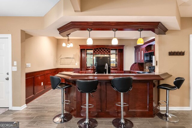 212 Postell Rd, Dallas, GA 30157 - indoor bar featuring black appliances, wood finished floors, wainscoting, and hanging light fixtures
