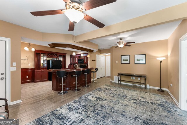 212 Postell Rd, Dallas, GA 30157 - kitchen featuring a kitchen bar, black appliances, ceiling fan, a peninsula, and light wood-type flooring