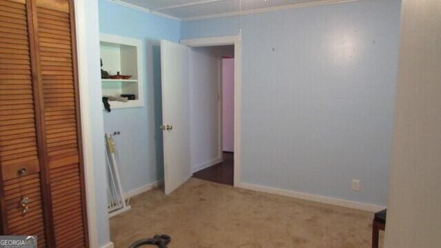 215 Poplar Cir, Lagrange, GA 30241 - unfurnished bedroom with a closet, crown molding, carpet flooring, and baseboards