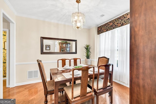 4174 Chatham Crest Ln, Buford, GA 30518 - dining area with a chandelier, light wood-style flooring, ornamental molding, and baseboards