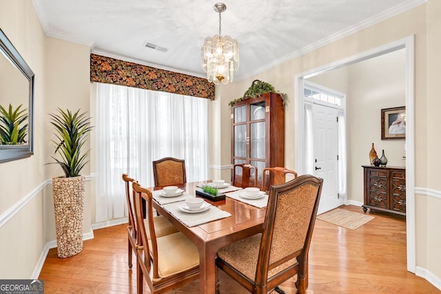 4174 Chatham Crest Ln, Buford, GA 30518 - dining room with light wood-style flooring, a chandelier, baseboards, and ornamental molding