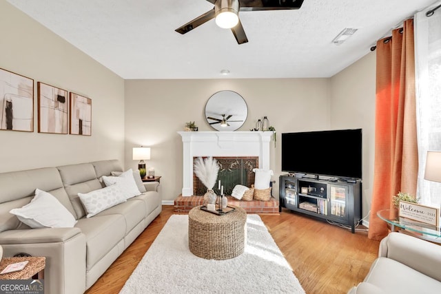 4174 Chatham Crest Ln, Buford, GA 30518 - living room featuring a ceiling fan, light wood-style floors, and a fireplace