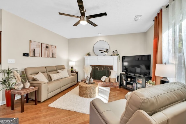 4174 Chatham Crest Ln, Buford, GA 30518 - living room with ceiling fan, light wood-style flooring, and a brick fireplace