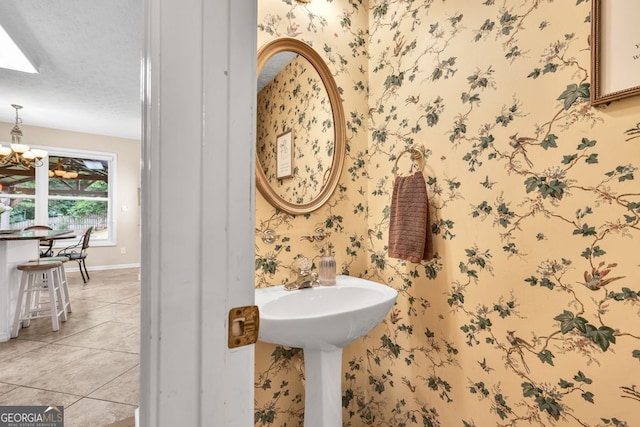 4174 Chatham Crest Ln, Buford, GA 30518 - bathroom with wallpapered walls, a chandelier, tile patterned floors, baseboards, and a textured ceiling