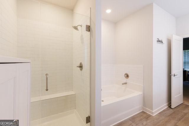 1225 Hibiscus Way, Mcdonough, GA 30253 - bathroom with a garden tub, a shower stall, baseboards, wood finished floors, and recessed lighting