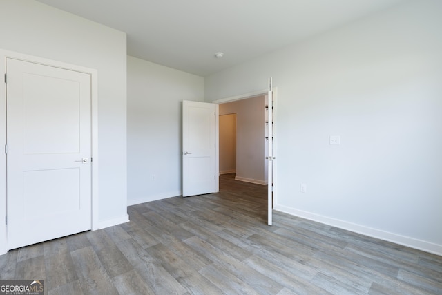 1225 Hibiscus Way, Mcdonough, GA 30253 - unfurnished bedroom with wood finished floors and baseboards