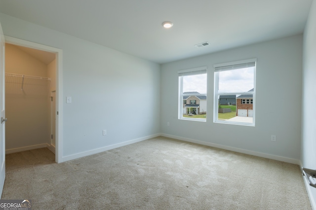 1225 Hibiscus Way, Mcdonough, GA 30253 - unfurnished bedroom with a walk in closet, carpet, baseboards, and a closet