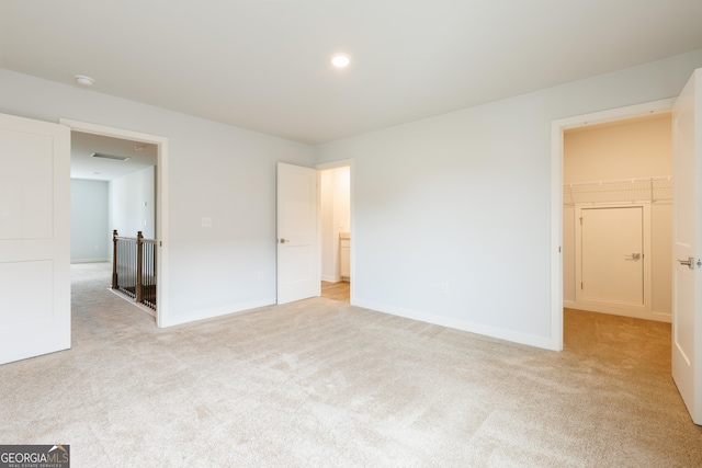 1225 Hibiscus Way, Mcdonough, GA 30253 - unfurnished bedroom with light colored carpet, a walk in closet, and baseboards