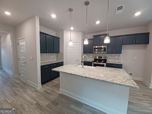 285 Magnolia Villas Dr, Cornelia, GA 30531 - kitchen with stainless steel appliances, a sink, decorative backsplash, a center island with sink, and baseboards