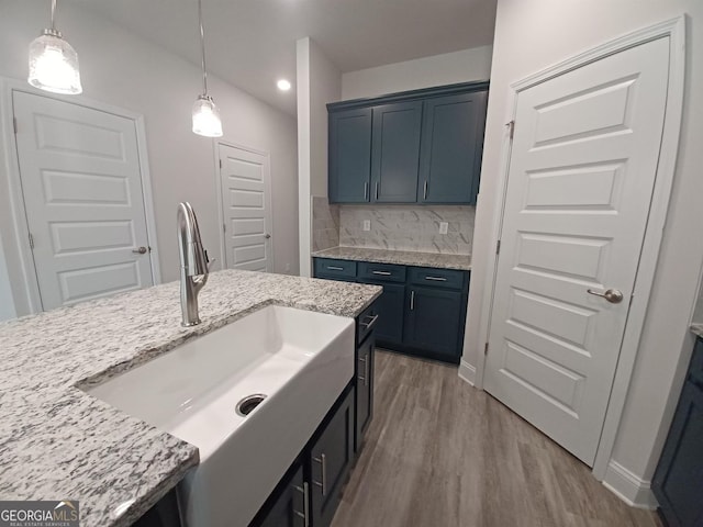 285 Magnolia Villas Dr, Cornelia, GA 30531 - kitchen featuring a sink, wood finished floors, pendant lighting, light stone counters, and decorative backsplash