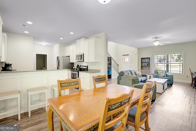 133 Coldwater Ln, Griffin, GA 30224 - dining area with stairs, a ceiling fan, light wood-style flooring, and recessed lighting
