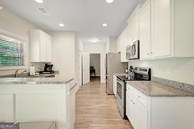 133 Coldwater Ln, Griffin, GA 30224 - kitchen featuring stainless steel appliances, light wood-style flooring, white cabinets, recessed lighting, and light stone countertops