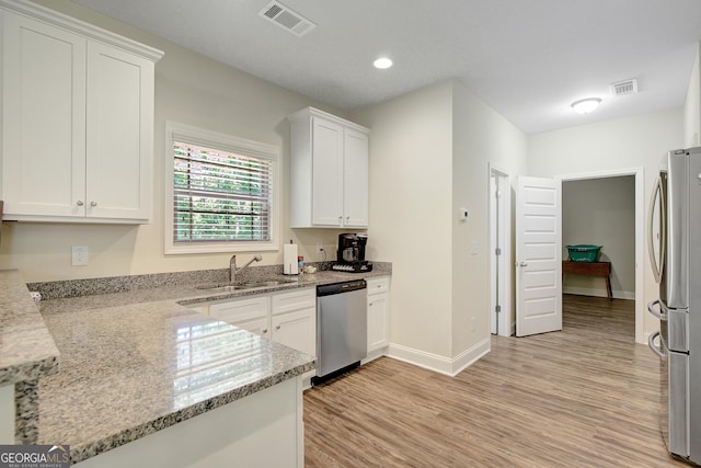 133 Coldwater Ln, Griffin, GA 30224 - kitchen with stainless steel appliances, white cabinets, light wood-type flooring, light stone countertops, and recessed lighting