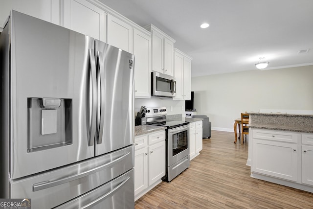 133 Coldwater Ln, Griffin, GA 30224 - kitchen with stainless steel appliances, white cabinets, light wood-style floors, light stone countertops, and recessed lighting