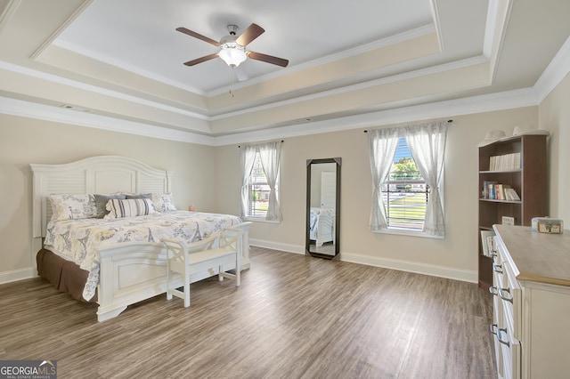 133 Coldwater Ln, Griffin, GA 30224 - bedroom featuring a raised ceiling, wood finished floors, multiple windows, ceiling fan, and crown molding