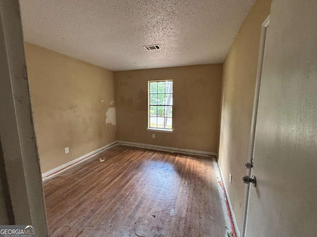 1090 Forest Path, Stone Mountain, GA 30088 - empty room with wood finished floors and a textured ceiling